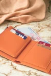 کیف پول زنانه نارنجی شیک چرم نرم با اکسسوری جا کارتی و زیپ دار - 2040