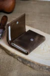 کیف پول مردانه قهوه‌ای با مکانیزم کارتی و محافظ RFID از جنس چرم طبیعی، همراه با جعبه کادویی | پِسکول - 4492