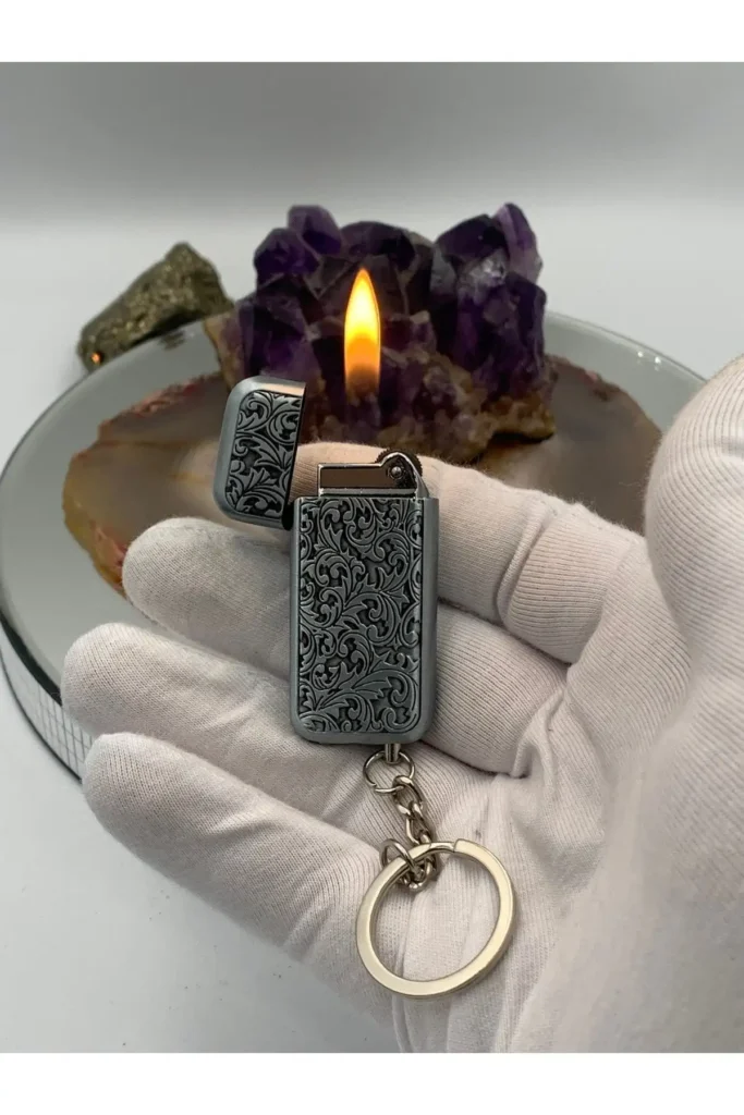 فندک کوچک و ظریف با طراحی شیک و لیزر حکاکی شده، رنگ نقره‌ای و دارای حلقه کلید، مناسب برای هدیه شخصی. - 8446